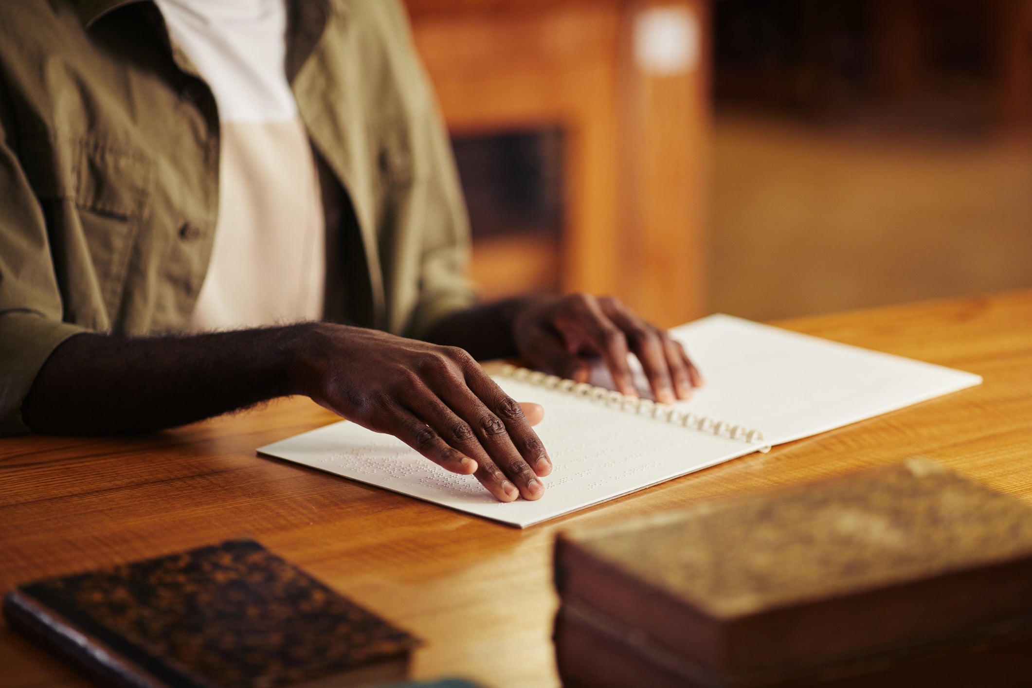 Black Man Reading Braille Book in Library