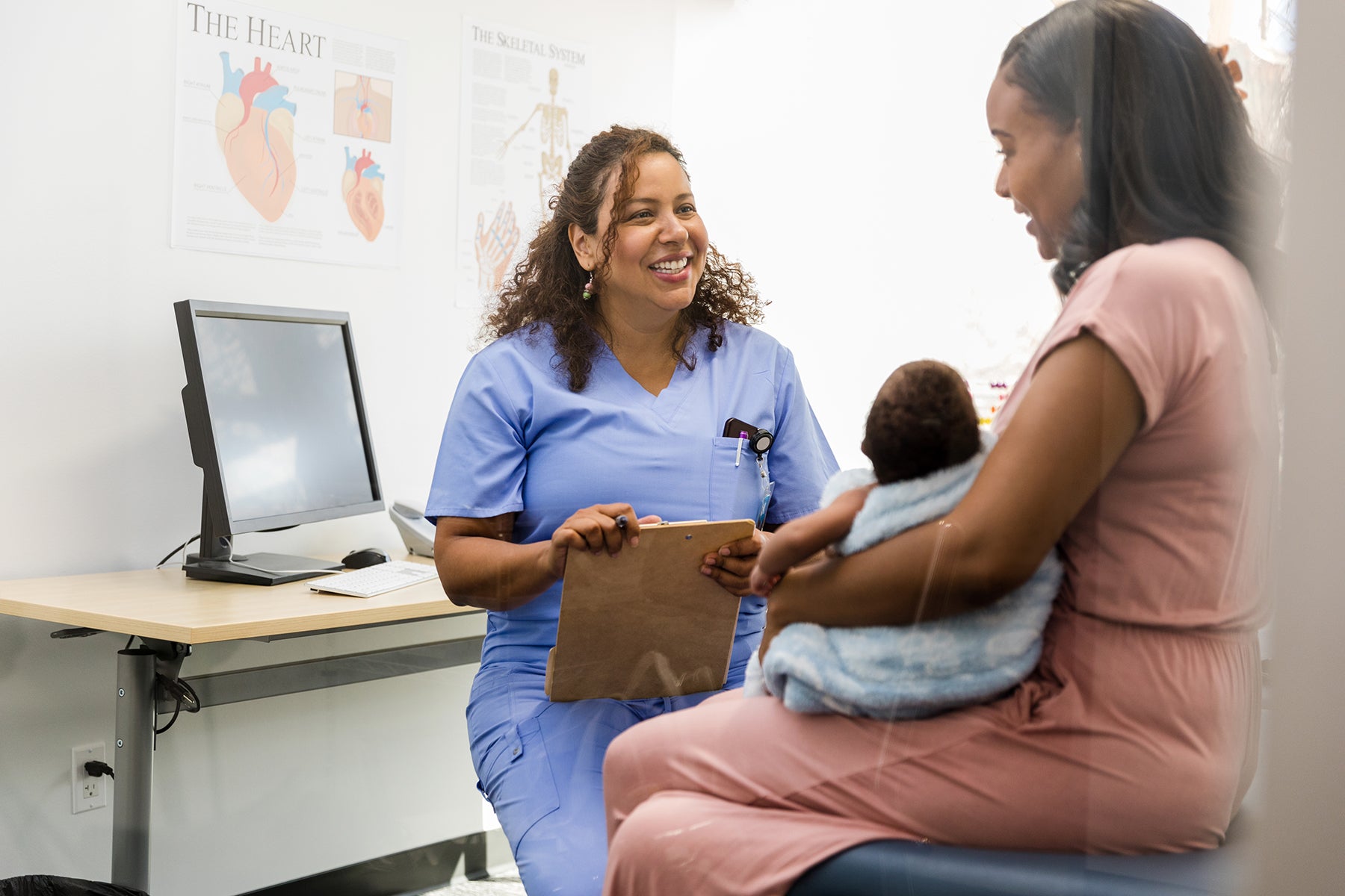 Specialist smiles while talking to the young adult mother about the encouraging test results