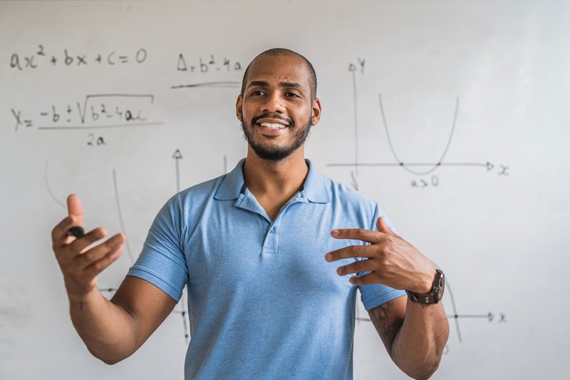 a man standing in front of a whiteboard with math on it.