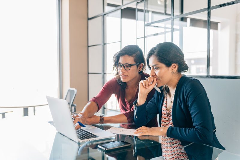 two women looking at a laptop